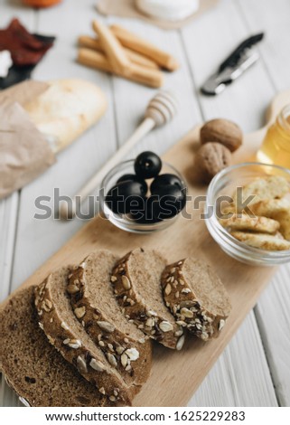 Flat lay with assorted food, glass for wine and nuts on light surface 