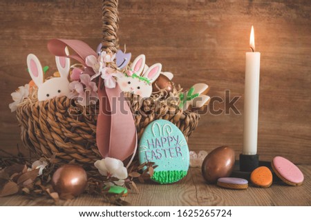 Happy Easter. Multicolored pastel easter cookies in a wicker basket  on a wood background. Easter concept