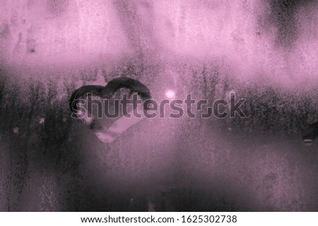 
drawing heart on misted glass black white photo with pink tinting