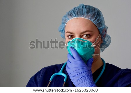 Close up of a female nurse putting on a respirator N95 mask to protect from airborne respiratory diseases such as the flu, coronavirus, ebola, TB, etc Royalty-Free Stock Photo #1625323060