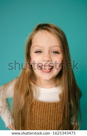 Emotional positive portrait of small young children in studio smiling young model girl