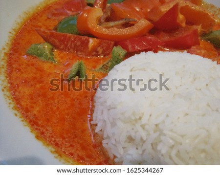 on a plate is rice and paprika with red sauce