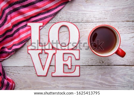Simple and cute romantic picture with a cup of tea and the word LOVE on a wooden background for Valentine's day