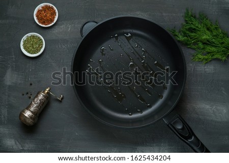 Man pouring cooking oil on the frying pan - Top View on a dark background Royalty-Free Stock Photo #1625434204