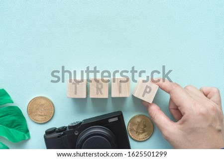 Top view of blank space decorate with travel accessories such as passport, camera, credit card and trip word on wood cube as frame of picture background. Travel vacation relax concept.