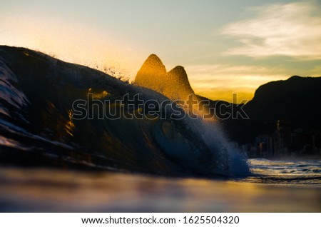 perfect breaking wave at the beach in the sunset