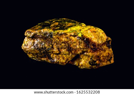 uranium mineral isolated on black background. Highly radioactive and dangerous ore. Royalty-Free Stock Photo #1625532208