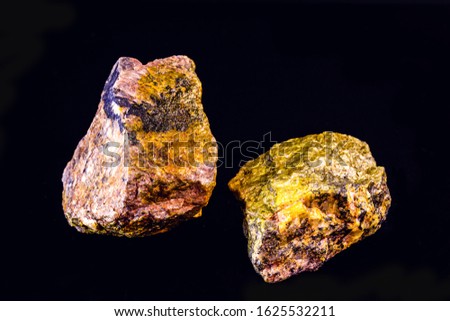 uranium mineral isolated on black background. Highly radioactive and dangerous ore. Royalty-Free Stock Photo #1625532211