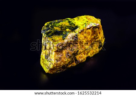 uranium mineral isolated on black background. Highly radioactive and dangerous ore. Royalty-Free Stock Photo #1625532214