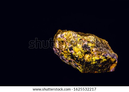uranium mineral isolated on black background. Highly radioactive and dangerous ore. Royalty-Free Stock Photo #1625532217