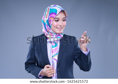 Half length portrait of an attractive Muslim woman wearing business attire and hijab with mixed poses and gestures isolated on grey background. For image cut-out for technology, business or finance.