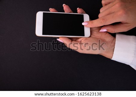 Woman presses finger on smartphone button. Woman using digital gadget.