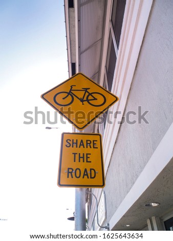 Yellow metal bicycle sign, share the road. Bicycle traffic yellow sign for cars to be aware of bicycle.