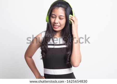 Too loud.  portrait of  young asian woman  holding  headphones and making unhappy face on white background