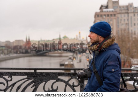 Man at the bridge looking at the distant Kremlin fortress during winter 