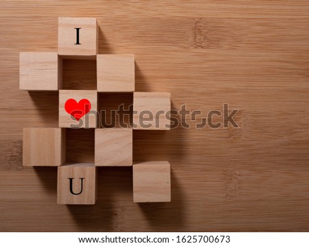 Word Love on wooden cubes with red heart, close-up near white background valentine concept