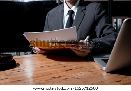 Justice and law concept. Lawyer businessman working with document at wood table office.