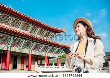 tourist woman with smart phone searching for travel information about temple 