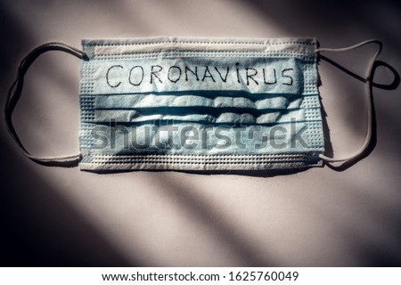 
Dramatic atmosphere with disposable surgical mask with coronavirus text written on it.2019-nCoV virus infection in Wuhan city. Covid-19 (SARS-CoV-2) spread around the world. Impact of pandemic virus. Royalty-Free Stock Photo #1625760049