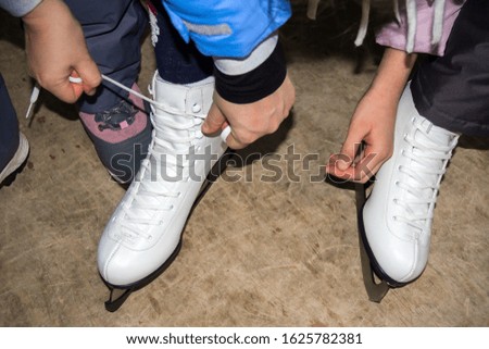 The child dresses skates for ice skating.