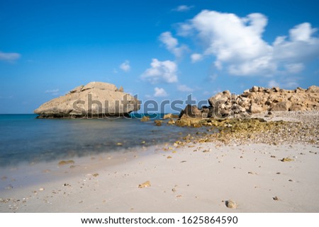 beautiful view on the lonely Fazayah Beach, Salalah Oman, Fantastic seascape, great outdoor scene of Beauty of nature concept background, blue sea, few clouds, light sandy beach, rocks in the water