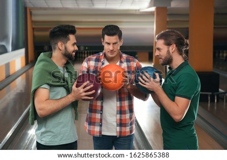 Group of men with balls in bowling club