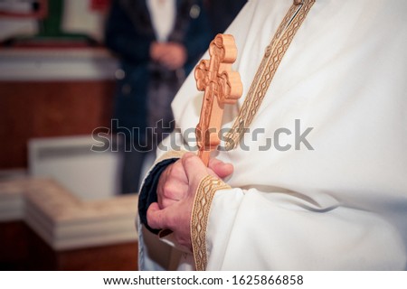 Ortodox priest holding a cross while christening  Royalty-Free Stock Photo #1625866858