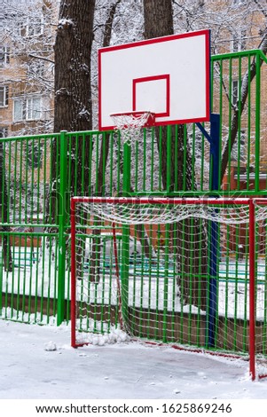 Basketball backboard on a city court with snow