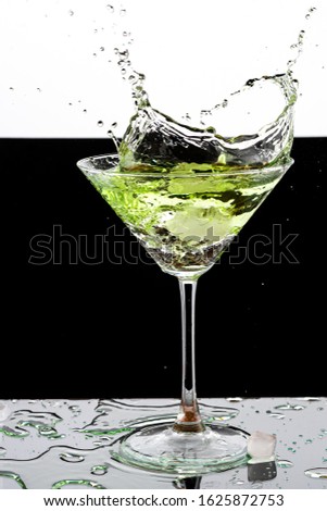 martini glass and splash from falling ice on a white background