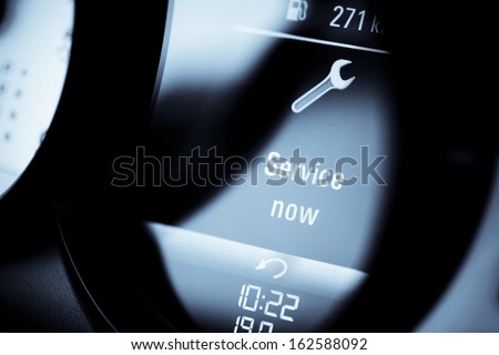 Detail with a warning icon on the dashboard of a car reading "Service Now". Royalty-Free Stock Photo #162588092