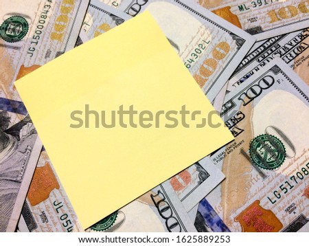 American cash money and blank yellow sticky note in aerial view