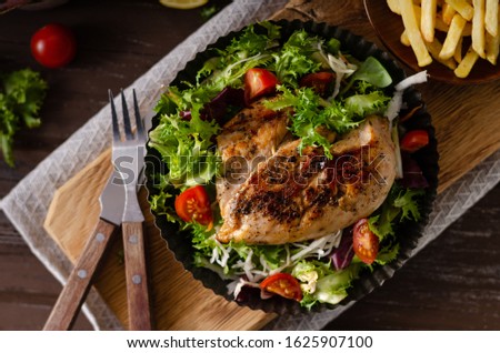 Fresh salad with tomatoes, grilled chicken and homemade french fries