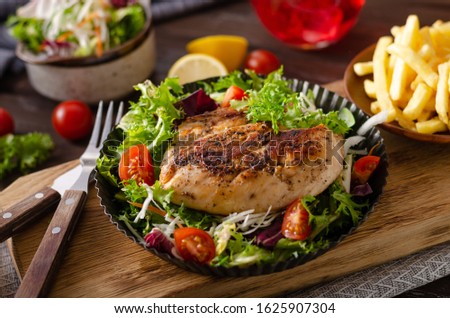 Fresh salad with tomatoes, grilled chicken and homemade french fries