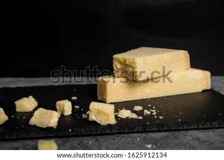 Grana Padano italian hard cheese on dark background Royalty-Free Stock Photo #1625912134
