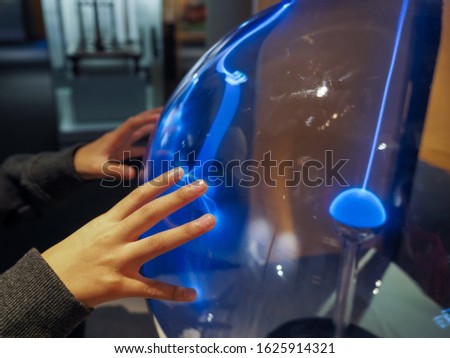 Closeup of a child hands touching an electrical ball at science museum. Selected focus.