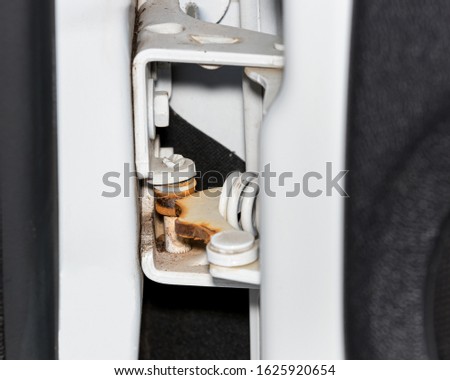 Closeup of rusty, squeaky, worn door hinge on pickup truck. Vehicle maintenance, service, and repair concept Royalty-Free Stock Photo #1625920654