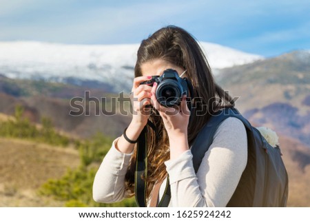 Woman in the High Snowy Mountain with Photo Camera.Winter Vacation Concept .Photographer in the Mountain 