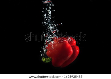 ripe pepper in water. Red and yellow vegetable splash water.