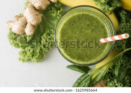 Freshly prepared glass of green smoothie, closeup. Fresh vegetable smoothie on a light background. Vegetable smoothie with spinach and kale cabbage.