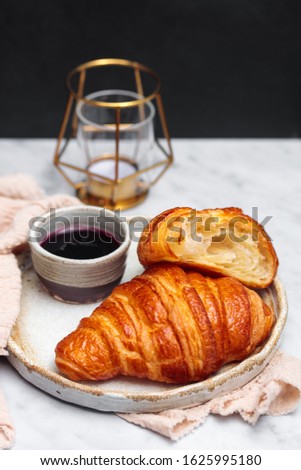 Fresh croissant with blueberry jam on white marble table. 