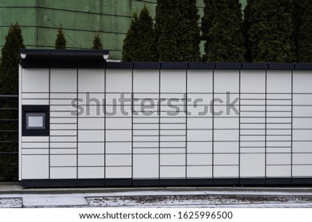 Boxes for parcels and letters on the street, an automatic machine for delivering parcels or ending machine or dispenser. Self-service post terminal machine or locker to deposit Royalty-Free Stock Photo #1625996500