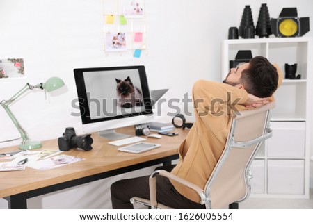 Professional photographer resting at workplace in office