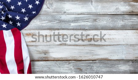 Waving United States Flag on left side of white rustic wooden Background  