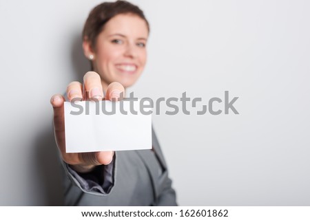 Friendly woman holding a business card and smiling
