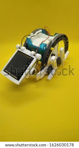 Robot assembled from parts on a solar panel Royalty-Free Stock Photo #1626030178