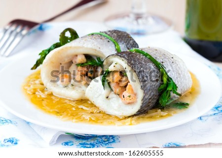 Fish rolls of dorado fillet stuffed shrimp and spinach with onion sauce of leek and wine