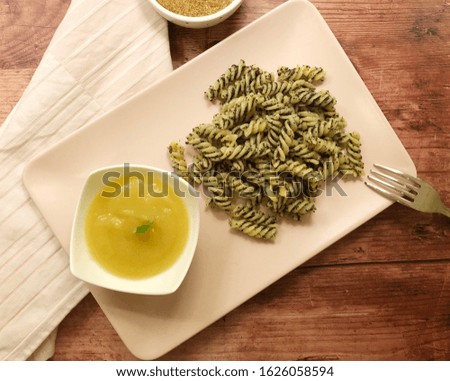 Sweet, classic poppy seeds pasta with apples sauce and sugar on wooden background.