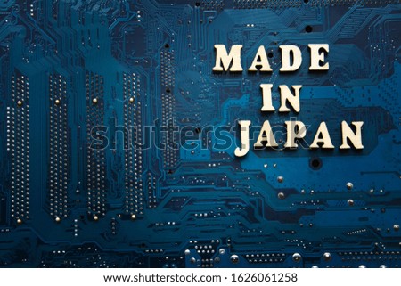 Sign Made in Japan on a blue electronic printed circuit board. Background with copyspace for design.