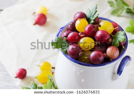 Organic fresh gooseberries in a bowl on a wooden background. Natural products for a healthy diet.