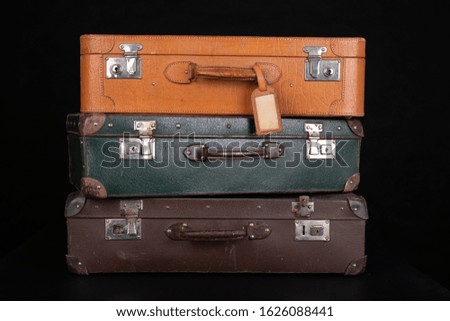 Old destroyed suitcases. Trunks used during long journeys. Dark background.